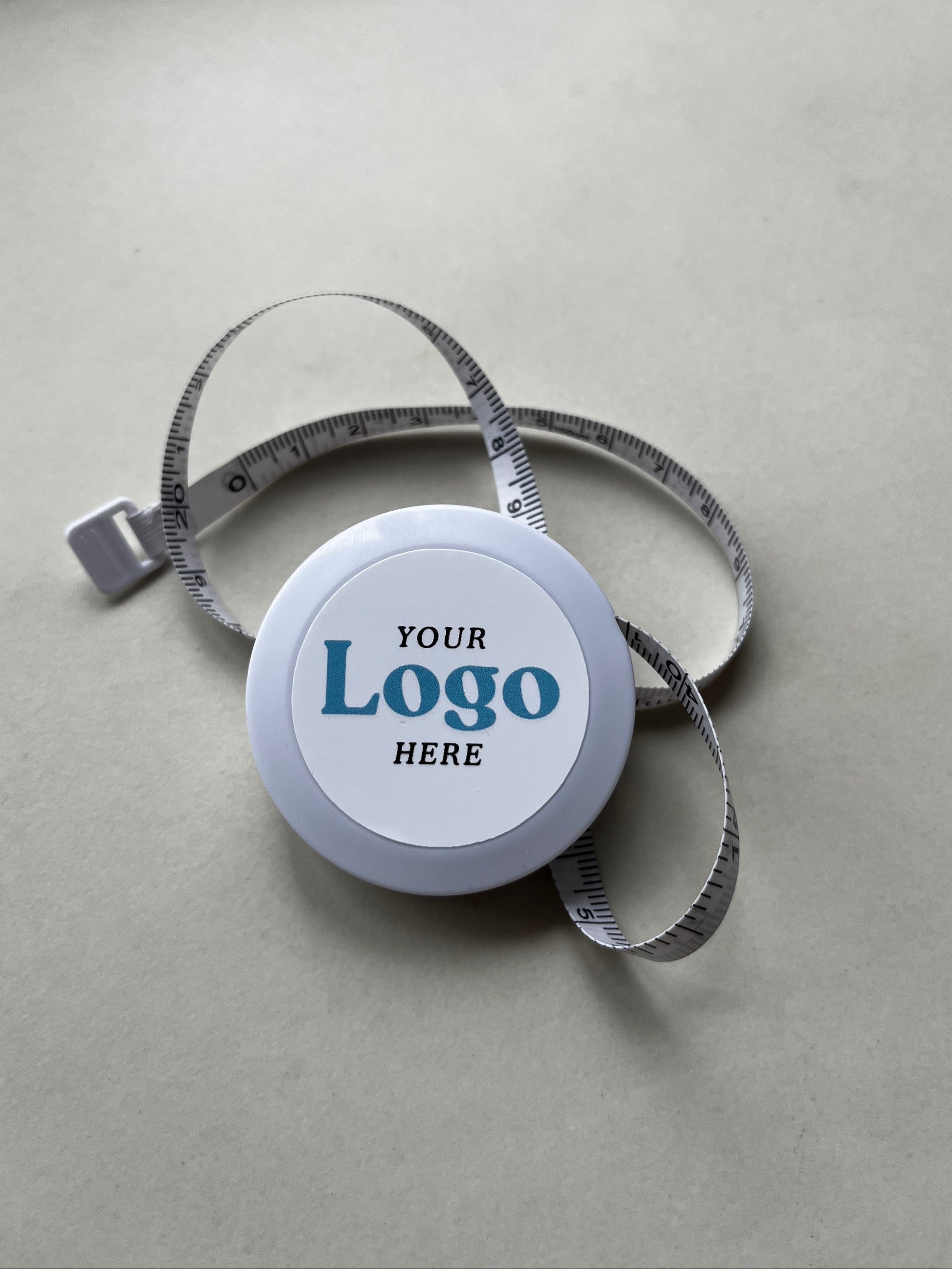 Tape measure with customizable logo on a marble stone background