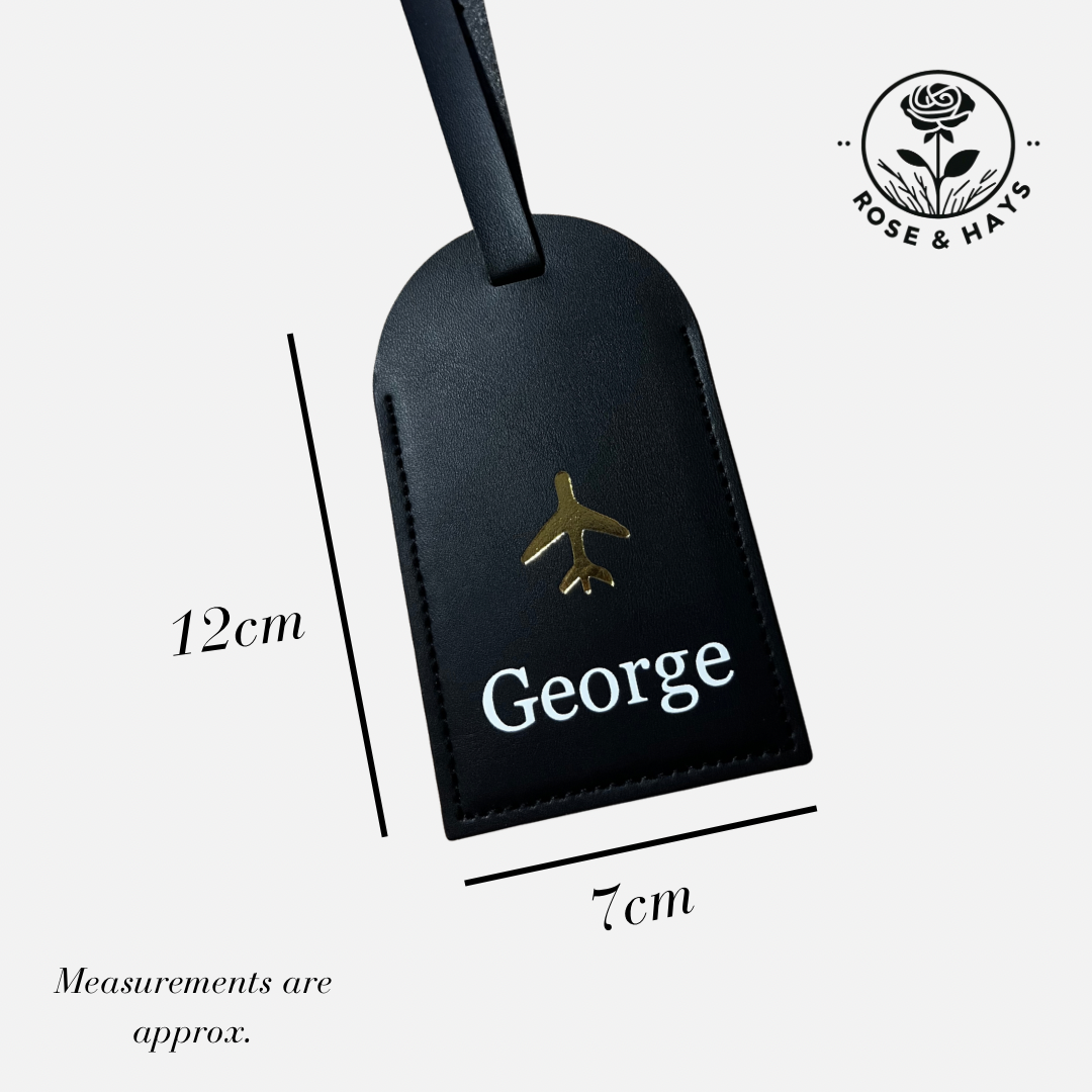Black luggage tag with 'George' and an airplane icon, featuring measurements 12 x 7cm and a brand logo (Rose & Hays).