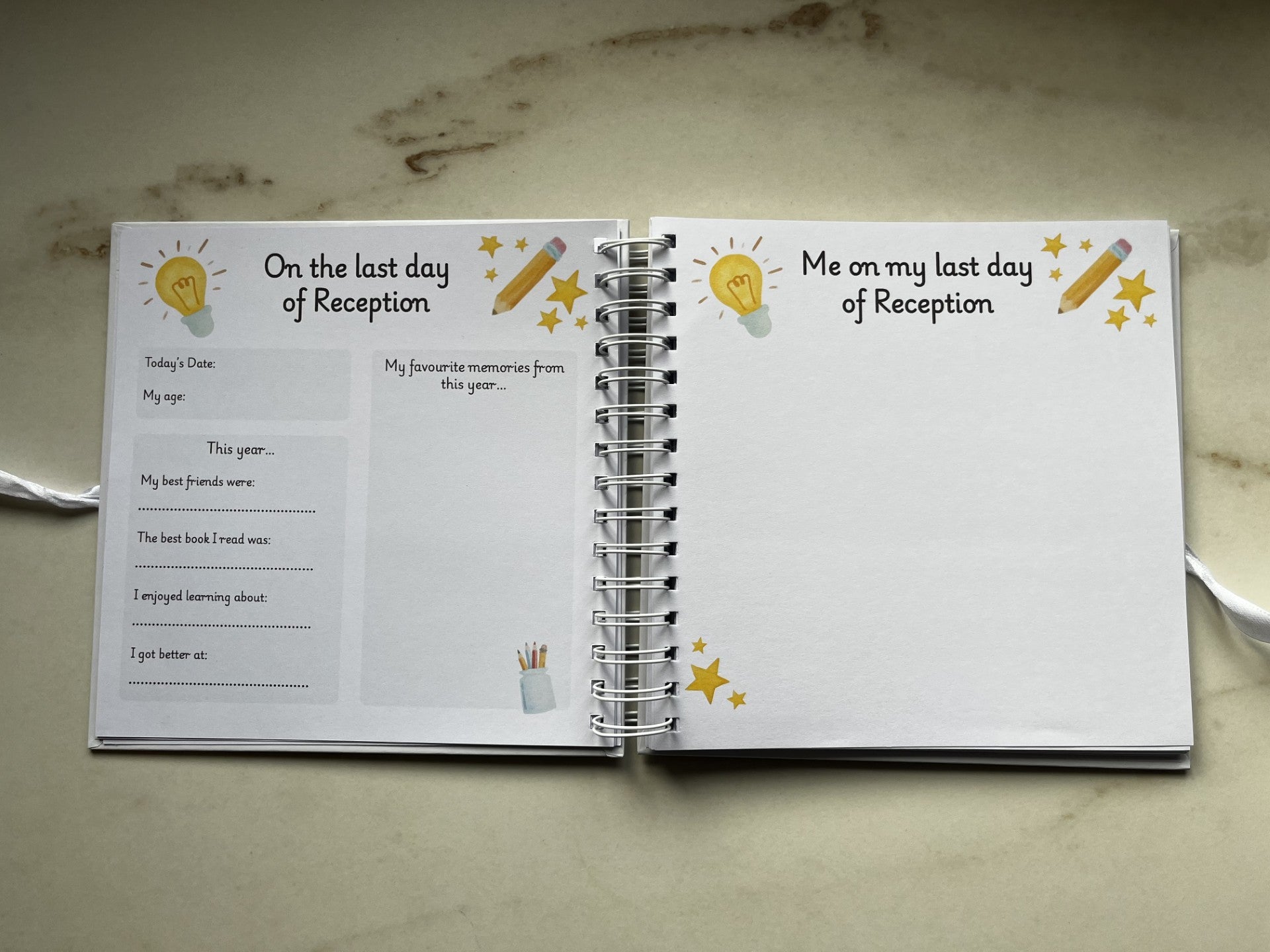 Open notebook with two pages titled 'On the last day of Reception' and 'Me on my last day of Reception' on a marble surface.