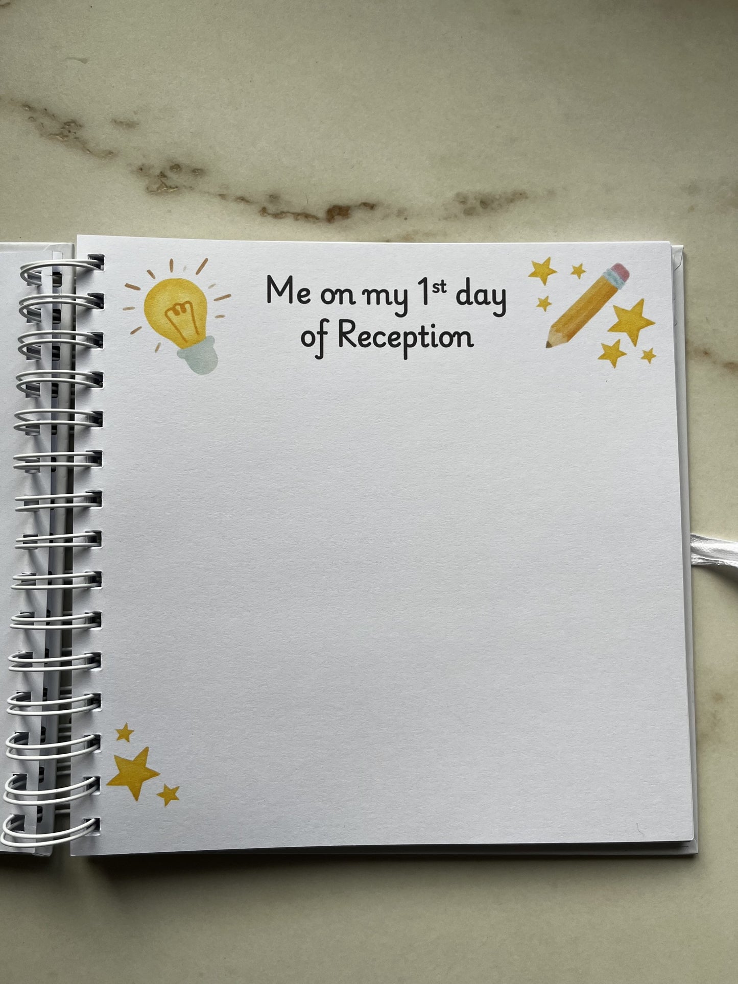 Memory book with 'Me on my 1st day of Reception' text and illustrations on a marble surface