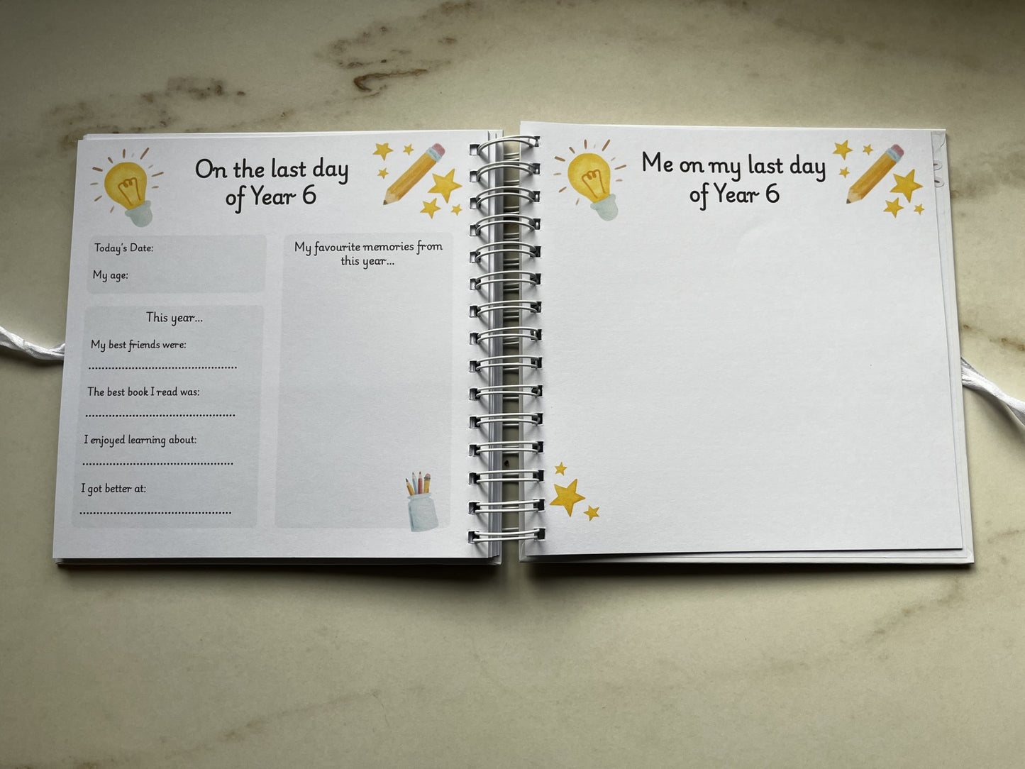 Open ring bound book with prompts for Year 6 students on a marble surface. Memories of year 6 primary school.