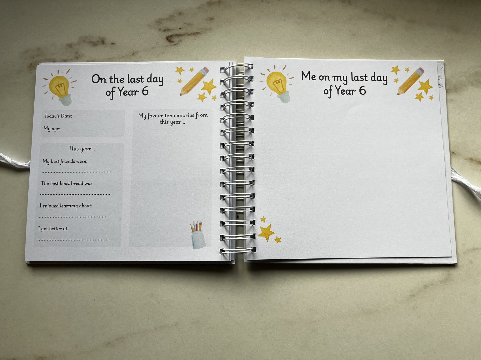 Open ring bound book with prompts for Year 6 students on a marble surface. Memories of year 6 primary school.